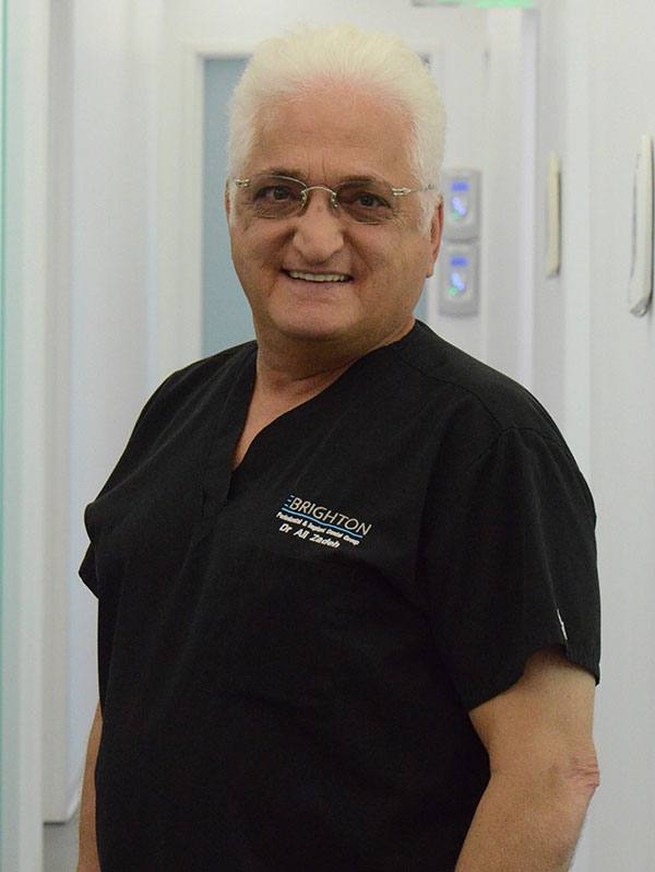 Dr. Ali Zadeh wearing Brighton dental group scrubs, smiling